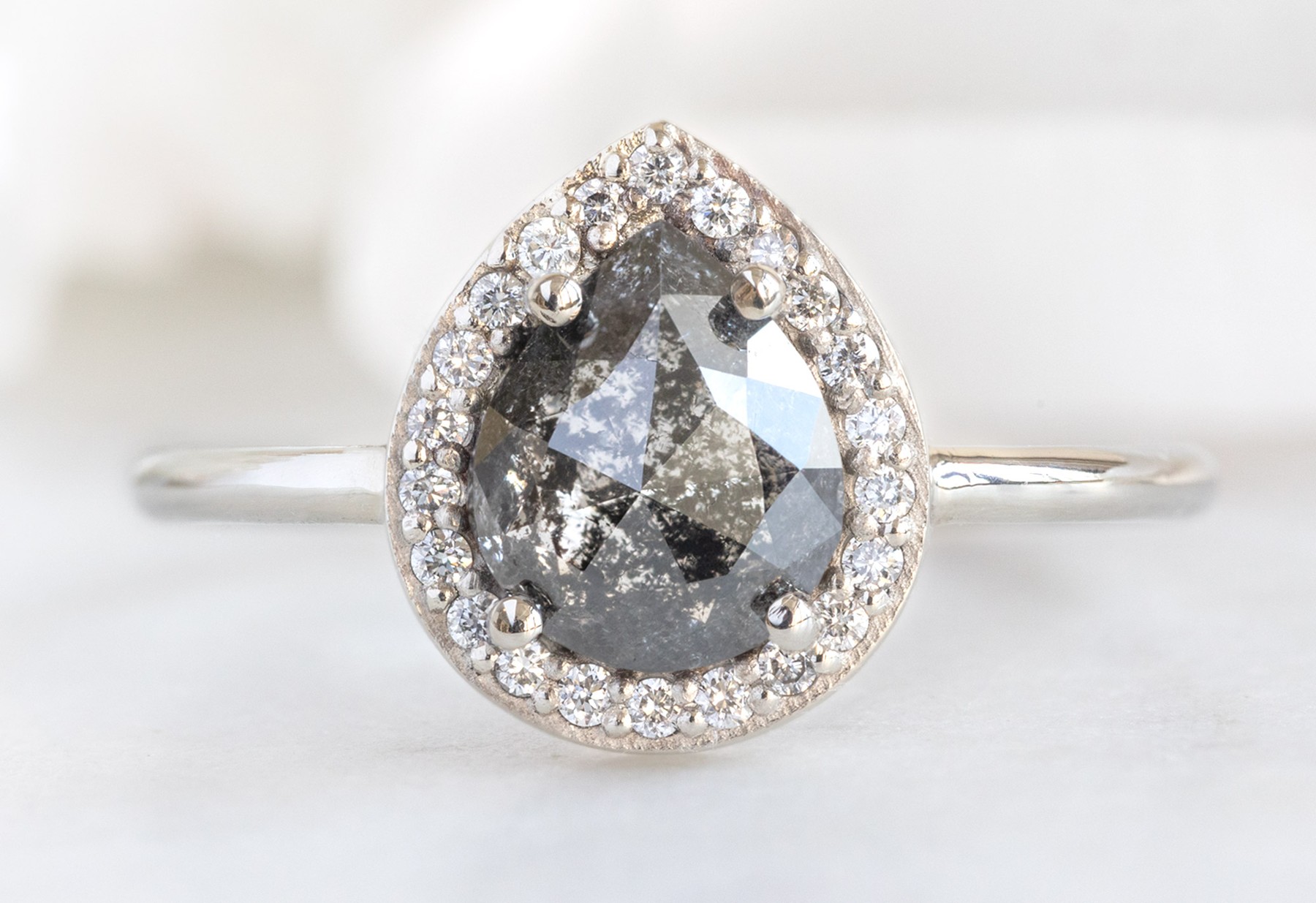 Pear-shaped black diamond ring photographed on white