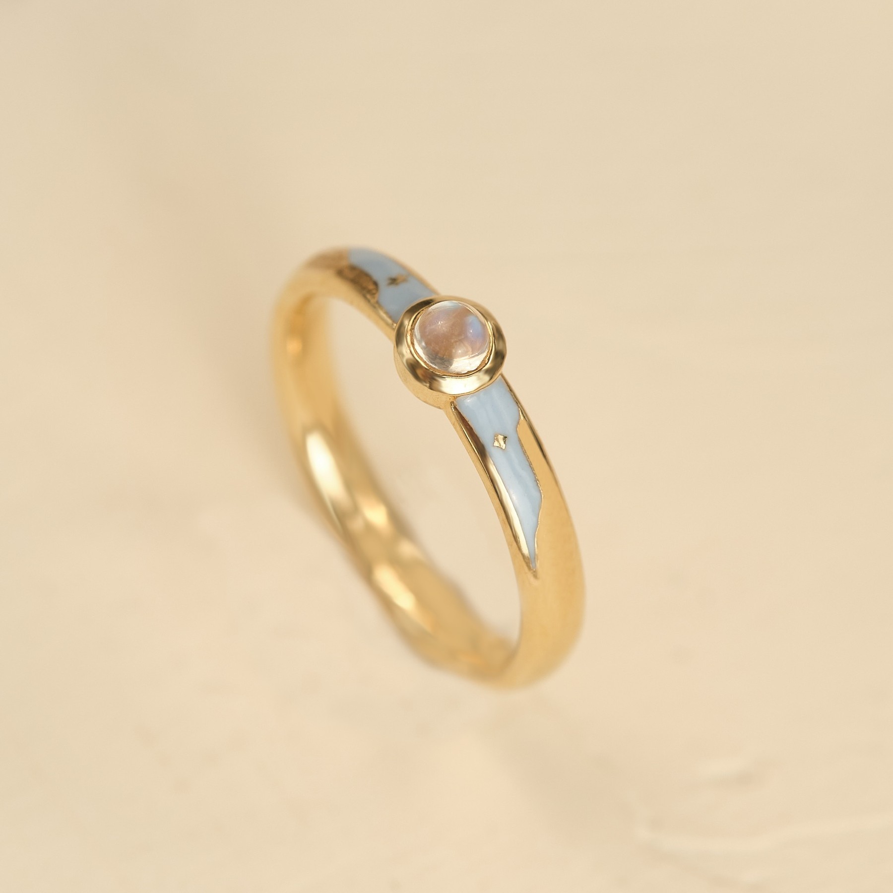 Blue and gold ring at an angle on a cream background